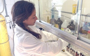 A BIOS NSF REU intern works in a fume hood in a lab