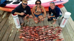 Researchers pose with a haul of invasive lionfish collected from Bermuda's waters