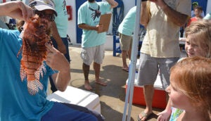 BIOS scientist Tim Noyes shows a lionfish to a young onlooker
