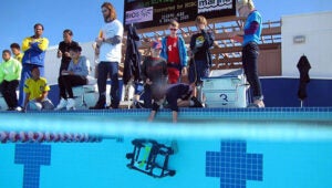 A student lowers his ROV into the pool at the National Stadium during the MARINE ROV Challenge