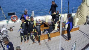 children wave from the deck of the Spirit of Bermuda sailing vessel
